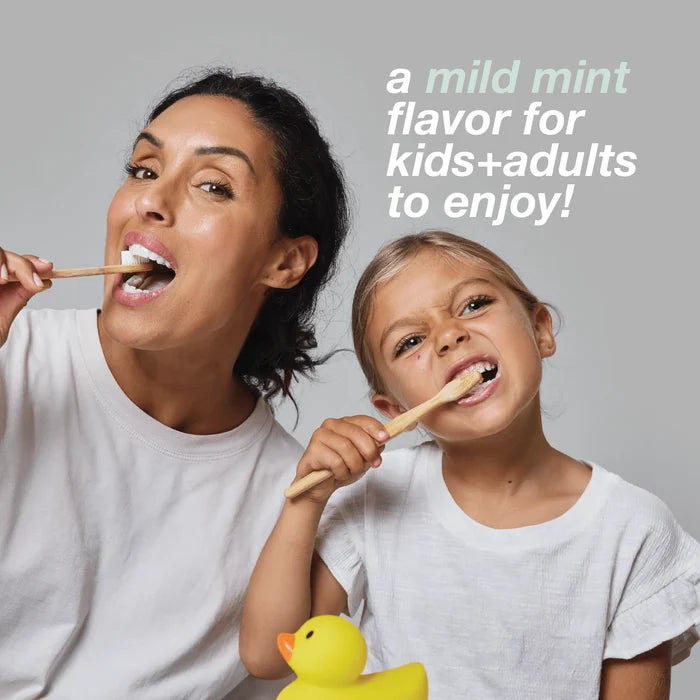 An adult and a child brush their teeth together, both smiling, while the child holds a yellow rubber duck. Text above reads: gentle mint for kids + adults to enjoy! Featuring Davids Hydroxi Whitening + Enamel Health Toothpaste with nano hydroxyapatite—fluoride free and naturally whitens for bright, healthy smiles.