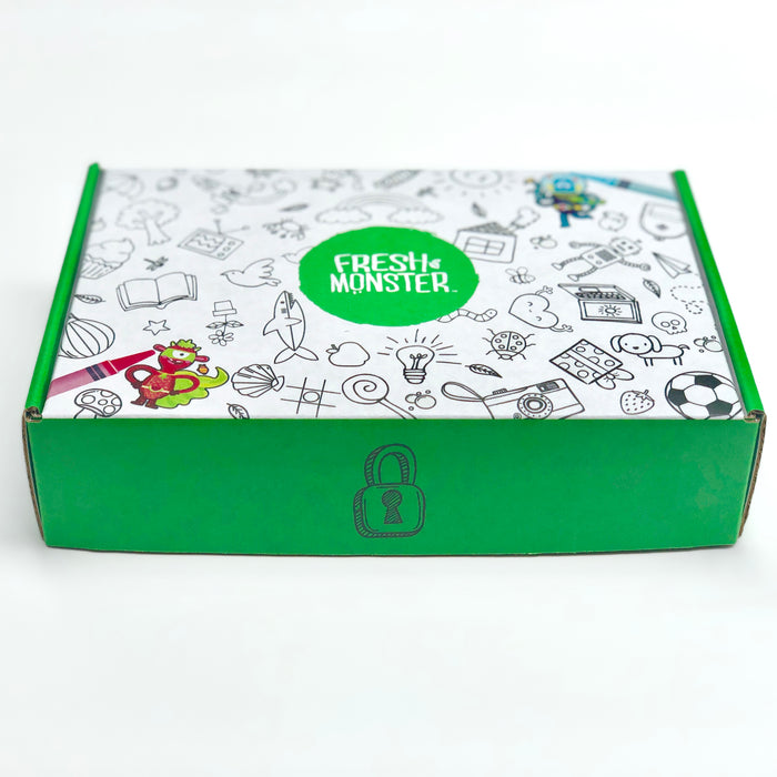 The Fresh Monster Kids & Baby Gift Set, great for gifting, comes in a green and white box with playful doodles of guitars, soccer balls, and light bulbs. The lid has a cartoon monkey with star and lock symbol doodles.