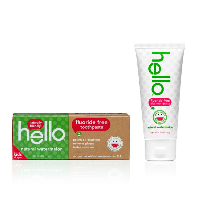 Box and tube of hello Kids Fluoride Free Toothpaste, Natural Watermelon. The box, vibrant in red, green, and white, is on the left with a fluoride free label. The tube stands to the right, echoing the playful design of this fluoride-free toothpaste for kids.