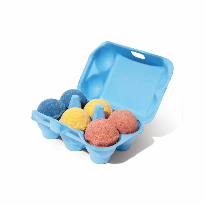 A blue egg carton from Pacha Soap Co. holds six colorful Kids Froth Bombs in blue, yellow, and red with the lid open, kid-safe and non-toxic against a white background.