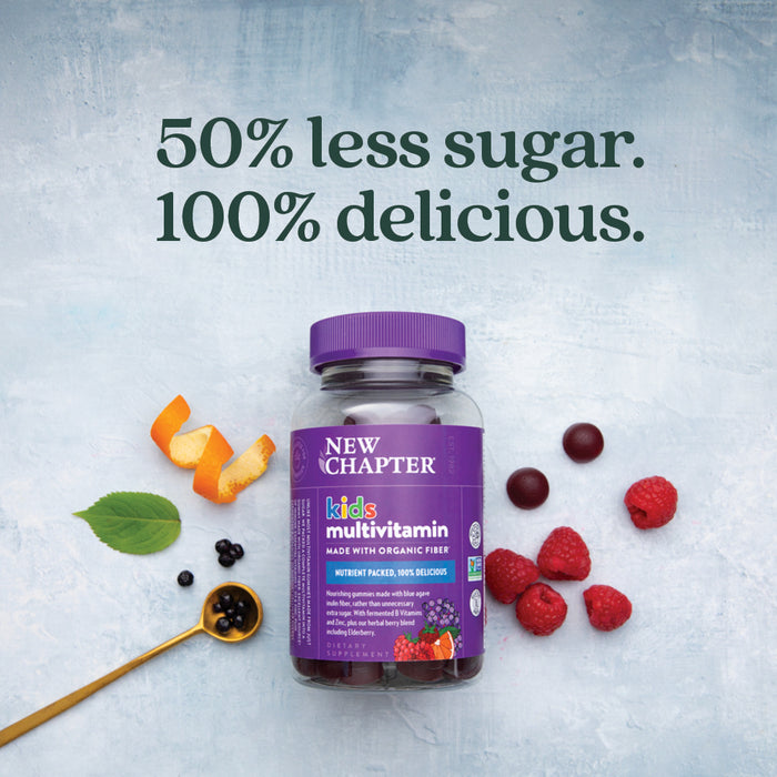 A bottle of New Chapter Kids Multivitamin Gummies, Berry Citrus Flavored, with a purple cap sits among raspberries, currants, orange peel, and a gummy. Text reads: “50% less sugar. 100% delicious.” Nutrient packed for growing kids’ immune health.