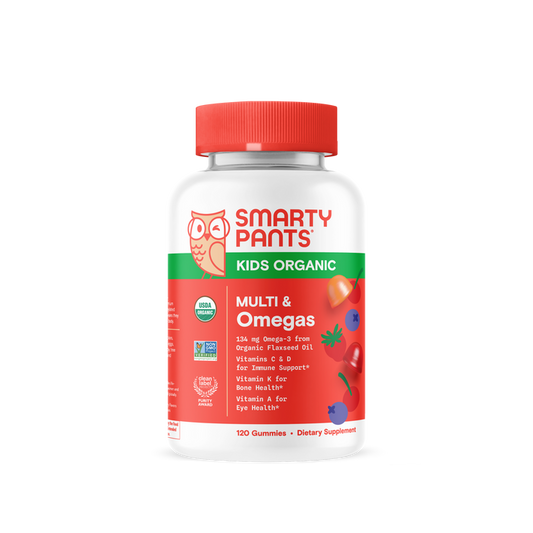 A bottle of SmartyPants Kids Organic Multi & Omega Gummies, with a red cap and label displaying tomatoes, carrots, and berries. These organic kids multivitamins are certified organic, provide essential nutrients, and deliver gluten-free vegetarian omega-3 gummies for children.