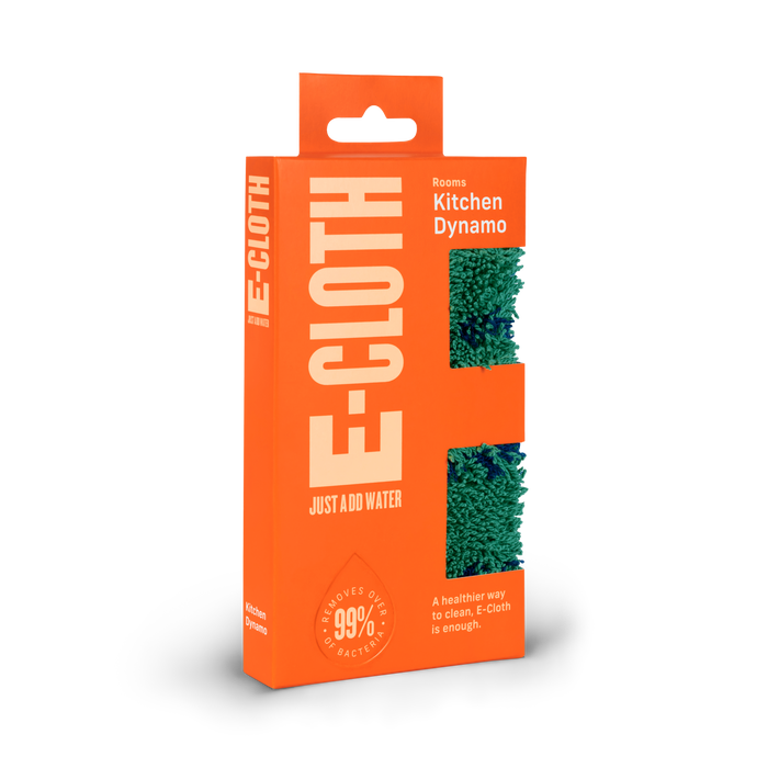 The E-Cloth Kitchen Dynamo Microfiber Scrubber is packaged in bright orange with a green scrubber visible through cutouts. It eco-consciously cleans by removing 99% of bacteria using only water for a healthier clean.