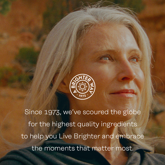 A woman with gray hair stands outdoors, looking thoughtful. The text reads, "Since 1973, we’ve scoured the globe for the highest quality ingredients to help you Live Brighter and embrace the moments that matter most." The logo says "Brighter Way 1973.