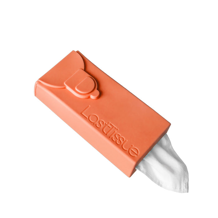 The LastObjects orange silicone LastTissue case features an eco-friendly design with reusable white tissues partially pulled out and a thumb-shaped closure, set against a plain white background.