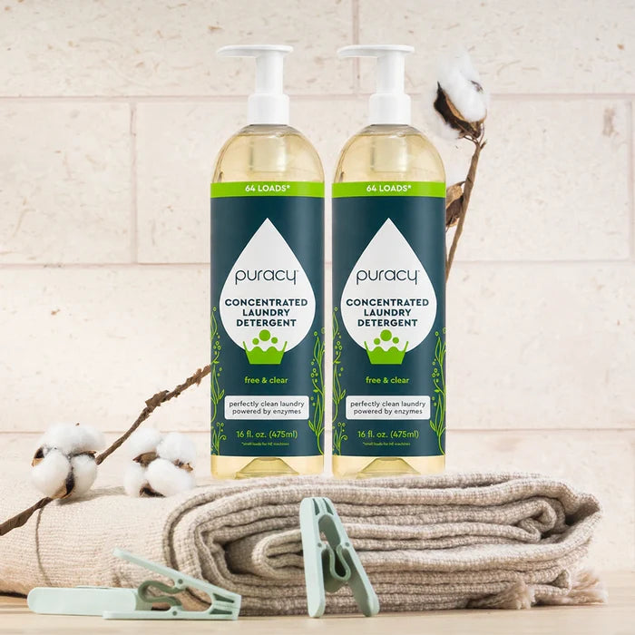Two bottles of Laundry Detergent (Concentrated, Sulfate-Free) on folded towels with clothespins and cotton.