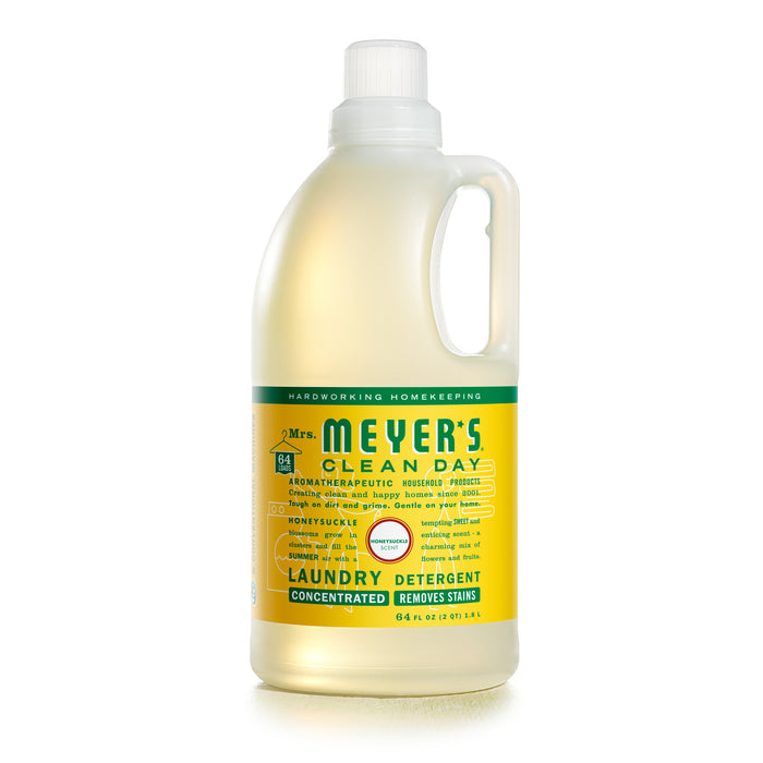 Mrs. Meyers Clean Day Laundry Detergent, 64 fl oz, has a yellow label with green text showcasing its stain-removing power and refreshing honeysuckle scent. The ergonomic handle guarantees easy pouring.