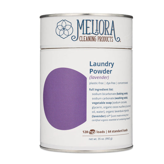 A white canister of Meliora Laundry Powder Canister, an eco-friendly laundry detergent in lavender scent, showcases a purple design and a detailed ingredient list. This concentrated laundry powder is MADE SAFE certified and delivers enough for 128 HE loads or 64 standard loads. Net weight: 35 oz (992 g).