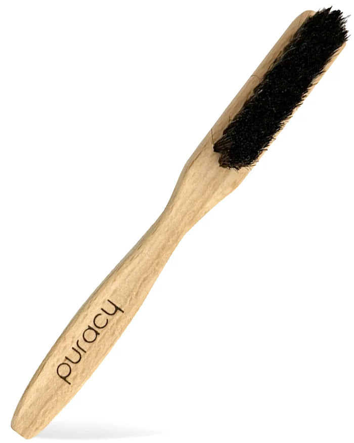 Wooden brush with black bristles on a white background, branded 'Puracy'.