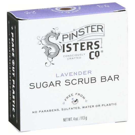 Spinster Sisters Co.s Lavender Sugar Scrub Bar comes in a white box with decorative swirls, emphasizing its exfoliating and hydrating effects. The packaging is plastic-free, paraben- and sulfate-free, waterless, and consciously crafted. Net weight: 4 oz.
