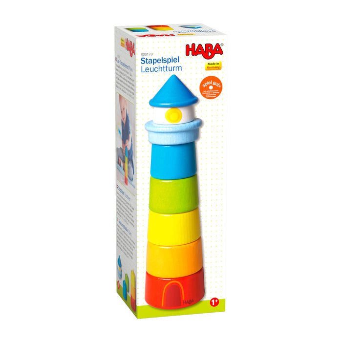 The HABA Lighthouse Wooden Rainbow Stacker, designed for ages 1+, is a vibrant toy with segments in red, orange, yellow, green, blue, and white. Made from sustainably sourced materials, it enhances motor skills and features prominent brand packaging.