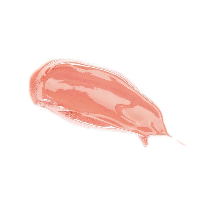 A smear of Lily Lolo Lip Gloss, a paraben-free liquid makeup, appears glossy and pinkish-peach against a white background, highlighting its smooth texture and radiant sheen.