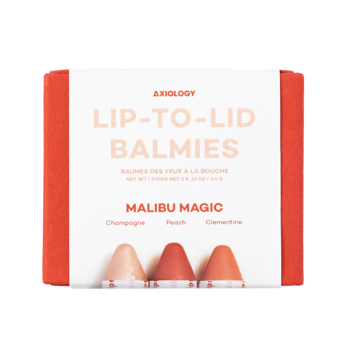 The Balmie Trio by Axiology includes vegan Lip-to-Lid Balmies in the shades Champagne, Peach, and Clementine. The vibrant orange packaging beautifully showcases these multi-use crayons with versatile hues at the bottom.