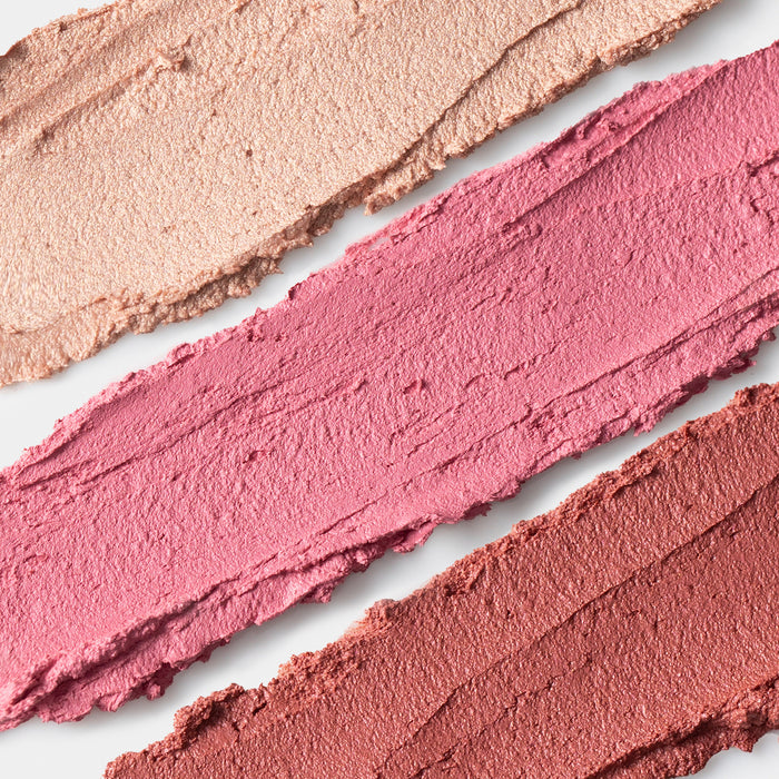 Three swatches of Axiology’s Lip-to-Lid Balmies Set - Cotton Candy Skies, featuring shades of pink and brown, lay parallel on a white background. Their smooth texture and rich tones shine as an eco-friendly choice in a recyclable case.