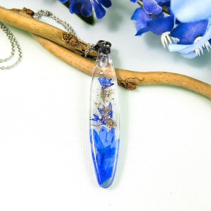 Crystal resin bar pendant featuring blue cornflower blooms with a stainless steel chain.