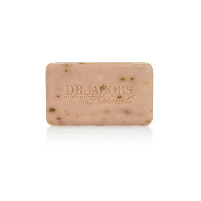 A beige Loofah Exfoliating Bar Soap by Dr Jacobs Naturals is embossed with its name and has a smooth surface with tiny dark specks, hinting at natural ingredients like coconut oil and organic shea butter for gentle exfoliation.