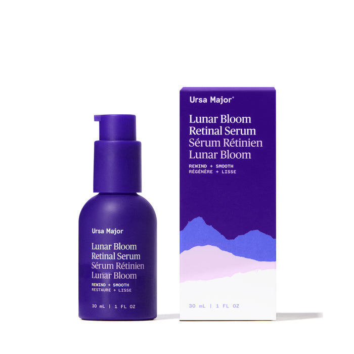 A 30 ml purple bottle of Ursa Major Lunar Bloom Retinal Serum stands beside its box with mountain graphics and bilingual details. This serum targets fine lines and helps even skin texture.