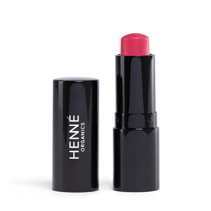 A tube of Luxury Lip Tint from Henné Organics with the cap off reveals a vibrant pink shade. The sleek black case, bearing HENNÉ ORGANICS in white, adds elegance to your natural lip routine.