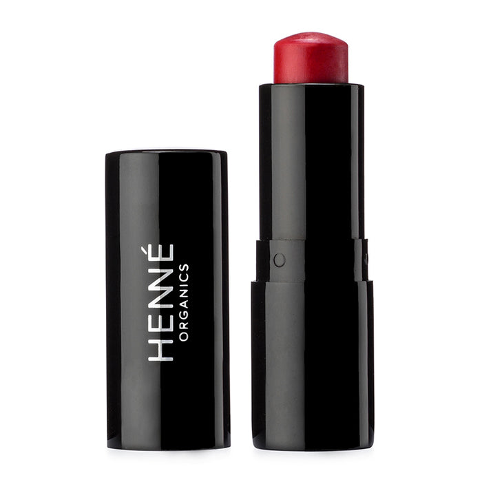 A sleek black tube labeled Henné Organics showcases their Luxury Lip Tint, a natural lipstick with its cap off to reveal a rounded red tip. Set against a white background, it epitomizes timeless elegance and sophistication.