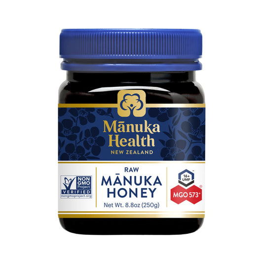 The 8.8 oz jar of Manuka Healths raw Manuka Honey features a blue lid and boasts UMF 16+ and MGO 573+ ratings. Its Non-GMO verified, catering to honey enthusiasts seeking premium quality.