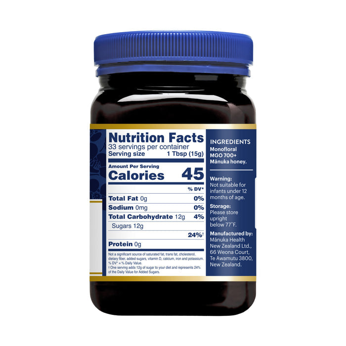 A jar of Manuka Healths Manuka Honey MGO 700+ / UMF 18+ with a blue lid features nutrition facts: 45 calories per tablespoon, 0g fat, 0mg sodium, and 12g carbohydrates. Ingredients: Monofloral MGO 700+ Manuka honey. Not suitable for children under 12 months.