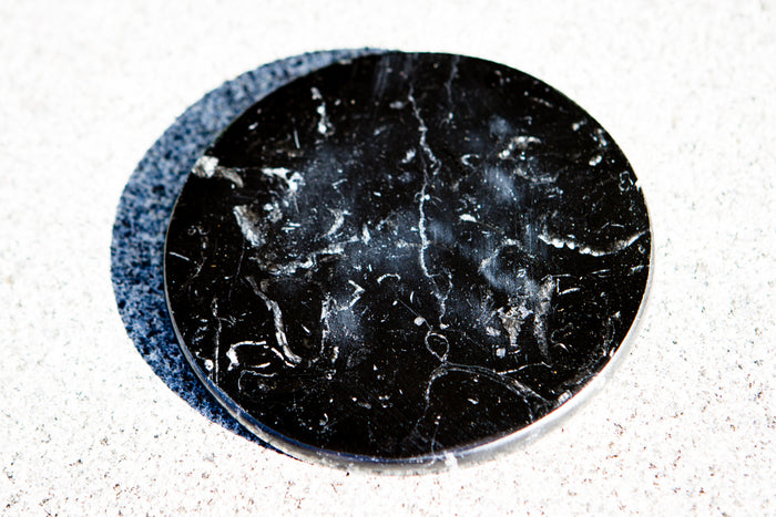 3.5 inch black marble display base for showcasing glass orbs and paperweights.