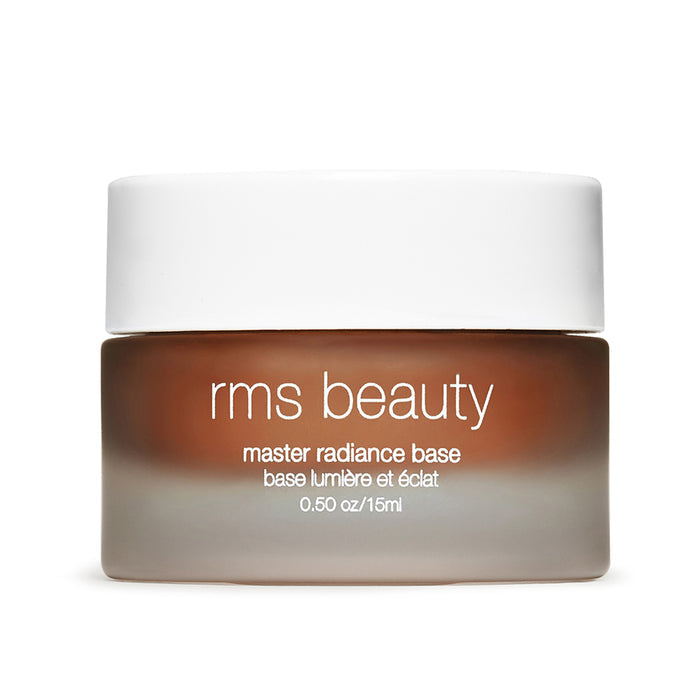 A small frosted glass jar with a white lid labeled RMS Beauty Master Radiance Base 0.50 oz/15ml, featuring Organic Jojoba for a naturally radiant glow.