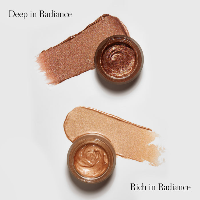 Two open jars of RMS Beautys Master Radiance Base—shimmery creams in bronze Deep in Radiance and gold Rich in Radiance—feature swatches and Organic Jojoba to illuminate skin with a radiant glow.