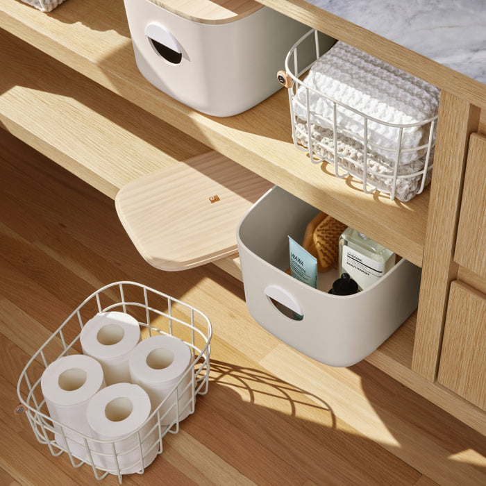 Open Spaces Medium Storage Bins with Wooden Lids provide versatile bathroom storage; the top shelf holds a basket for folded towels, the middle has an open bin for toiletries, and the bottom shelf features a basket with three rolls of toilet paper, keeping your space as tidy as any pantry.