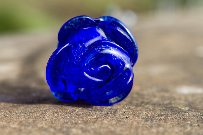 Close up of cobalt blue memorial glass rose with a clear stem