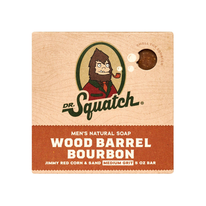 Dr. Squatch Mens Bar Soap in Wood Barrel Bourbon features a bearded man with a pipe on the packaging, highlighting notes of Jimmy Red Corn & Sand, and Medium Grit. Weighing 5 oz, it captures rustic charm and rugged sophistication.