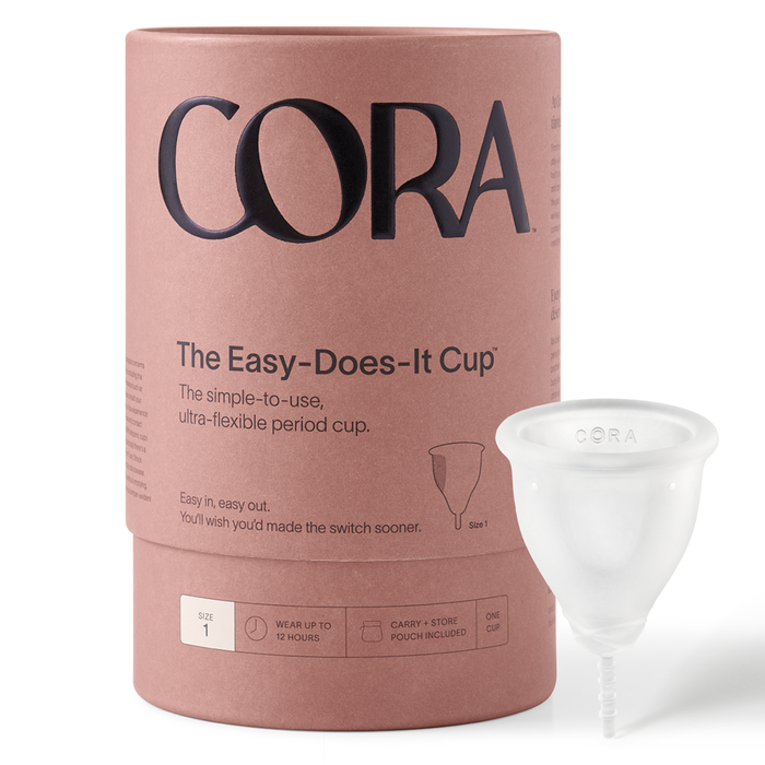 Coras Menstrual Cup packaging highlights eco-friendly period care with a pink cylindrical container and black text, showcasing simplicity and flexibility. A transparent Cora Menstrual Cup, Size 1, is elegantly displayed beside it.