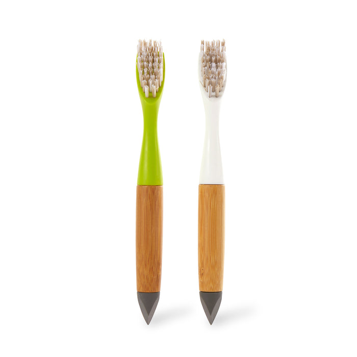 The Full Circle Micro Manager Detail Brush set features two bamboo-handled brushes with silicone tips—one green-necked, one white—standing upright on a white background, ideal for precise kitchen cleaning in hard-to-reach areas.