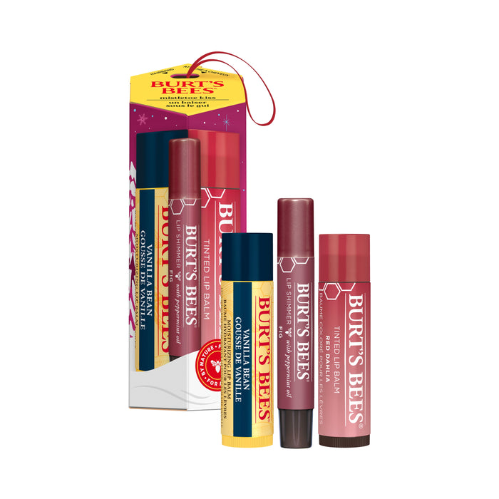 Displayed in front of a gift box, the Mistletoe Kiss Gift from Burts Bees includes a Vanilla Bean Lip Balm and two Tinted Lip Balms in yellow and pink tubes. The holiday-themed box, with a small red loop handle, makes it an ideal festive present.