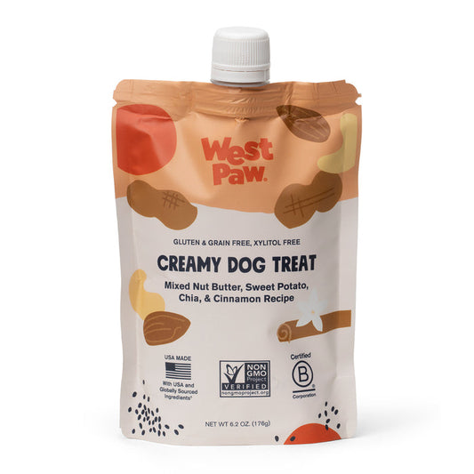 The Nut Butter Sweet Potato Creamy Dog Treat by West Paw comes in a cream-colored pouch adorned with nut graphics and a dog silhouette. It includes plant-based ingredients like mixed nut butter, sweet potato, chia, and cinnamon. Certifications are displayed below the text.