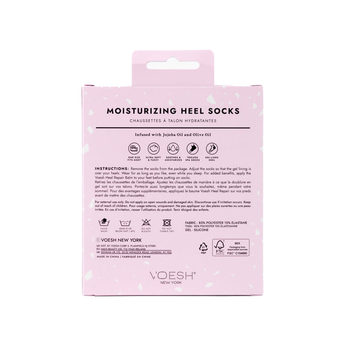 The light pink packaging of VOESH New Yorks Moisturizing Heel Socks showcases jojoba and olive oil ingredients, with instructions, fabric composition, and company details clearly visible. A small hanging tab at the top allows for easy display.