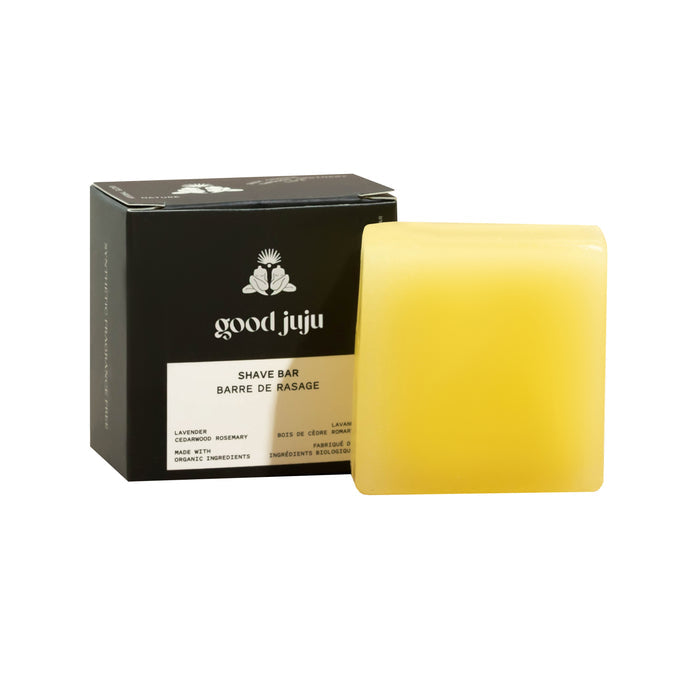 A yellow rectangular Moisturizing Shave Bar from Good Juju Body & Home sits before a black box with English and French text. Scented with lavender, cedarwood, and rosemary, this zero waste bar provides a gentle, moisturizing shave.