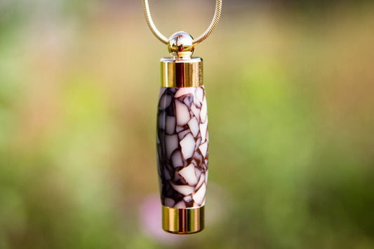 Handmade mosaic keepsake urn pendant with gold caps on a chain, designed to hold cremation ash or a lock of hair.