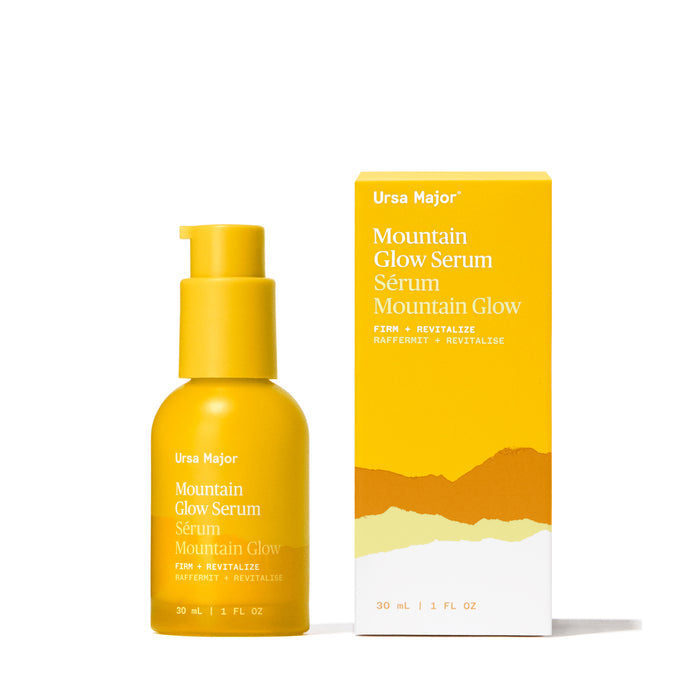 A yellow 30ml (1 fl oz) bottle of Ursa Major Mountain Glow Serum for skin nutrition and wrinkle care, shown with a matching box featuring mountain graphics and text, displayed on a white background.