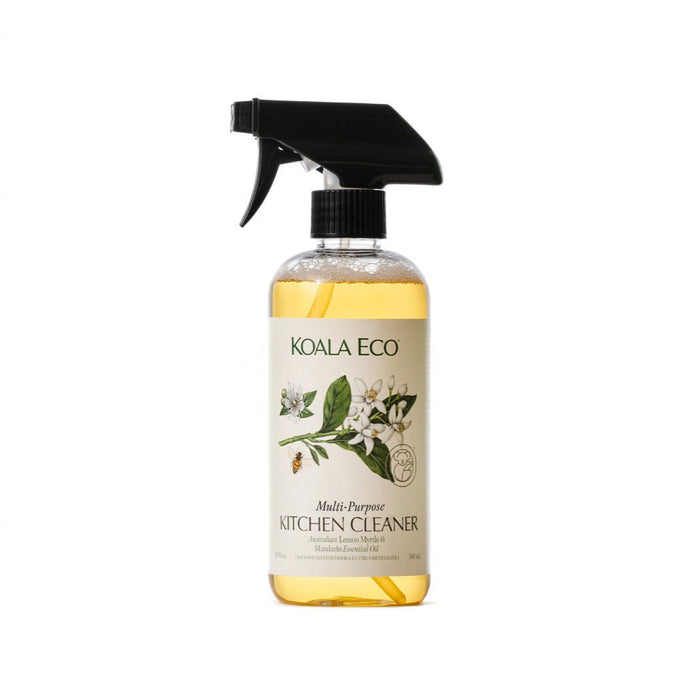 A clear spray bottle of Koala Eco Multi-Purpose Kitchen Cleaner features a black nozzle and a label with botanical illustrations, reflecting its natural formula inspired by lemon myrtle and mandarin. The light yellow liquid suggests fresh, eco-friendly cleaning.