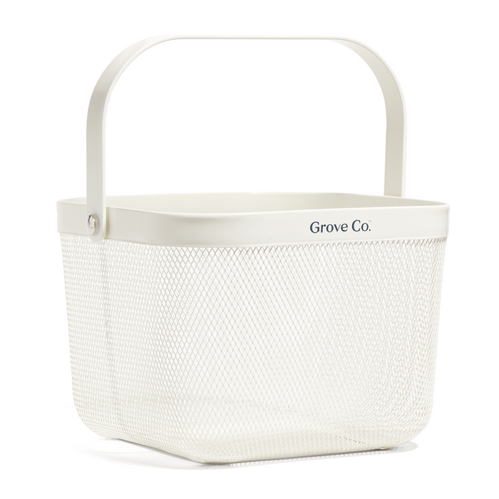 The Multi-Purpose Mesh Basket by Grove Co. is a white, rectangular caddy with a handle and branded text near the top edge, providing a stylish, plastic-free way to organize your essentials.