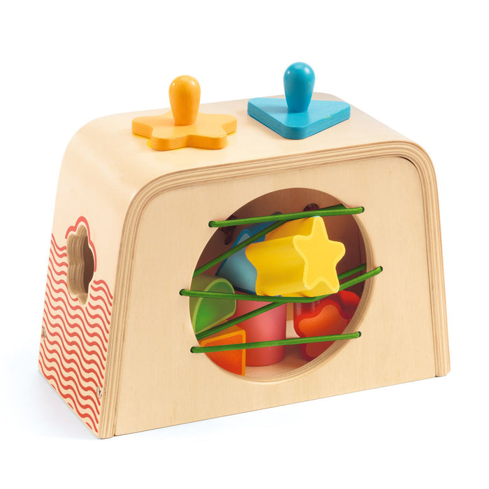 The DJECO Multi Sensory Wooden Shape Sorter Toy, made from FSC® Certified Wood, features colorful shapes like stars and triangles that fit through matching top and side holes. Red waves adorn the sides with green elastic bands for easy shape access.