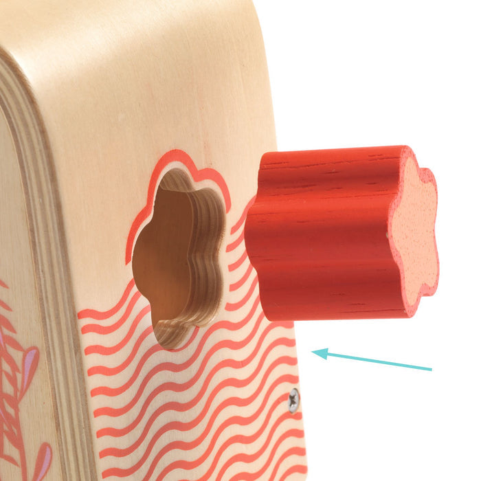 The DJECO Multi Sensory Wooden Shape Sorter Toy made from FSC® Certified Wood features a red star piece partially inserted into a matching hole, adorned with wavy lines and floral designs. An arrow guides you to complete this creative geometric puzzle.