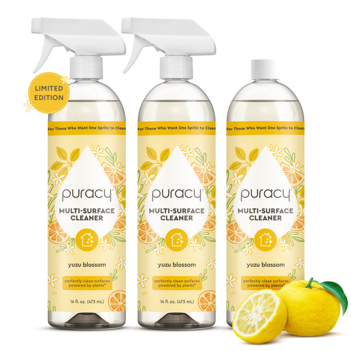 Three bottles of Multi-Surface Cleaner Spray with lemon and yuzu fruit in front.