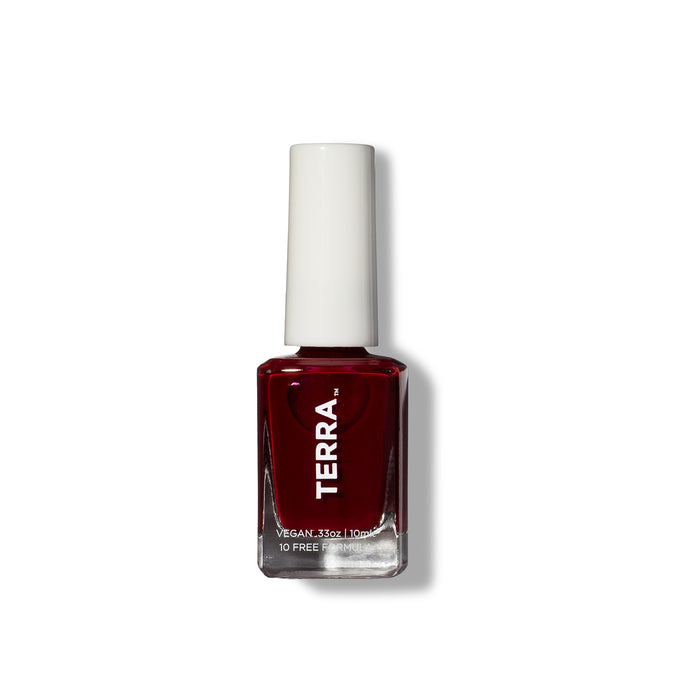 A deep red Terra Beauty Bars nail polish, featuring a white cap, is vegan and cruelty-free. This 10-free, plant-based bottle elegantly stands against a plain white background.