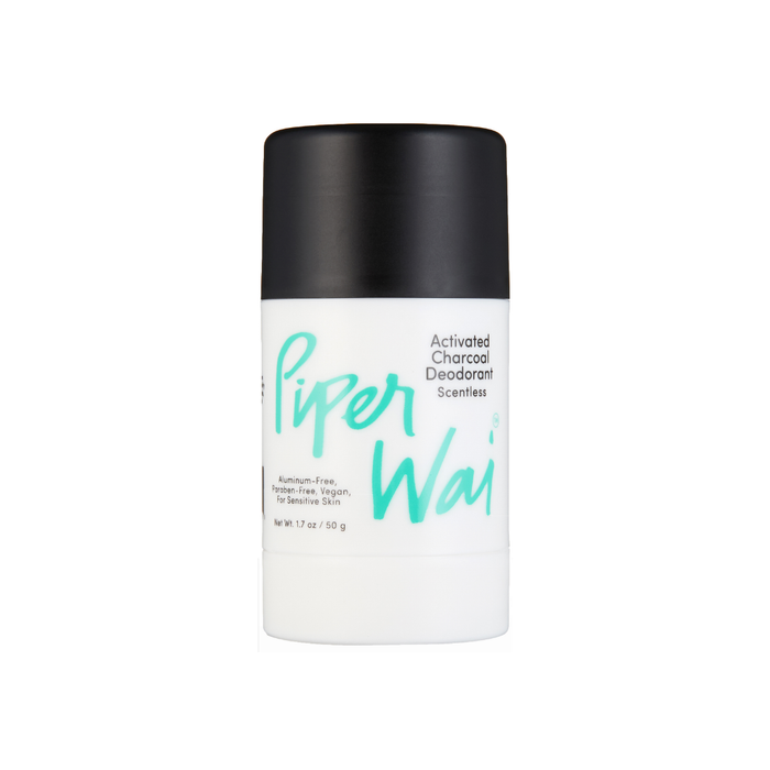 A white cylindrical deodorant stick with a black lid features the PiperWai Natural Deodorant label in turquoise text, highlighting its activated charcoal. Its aluminum-free, paraben-free, vegan, and gentle on sensitive skin.