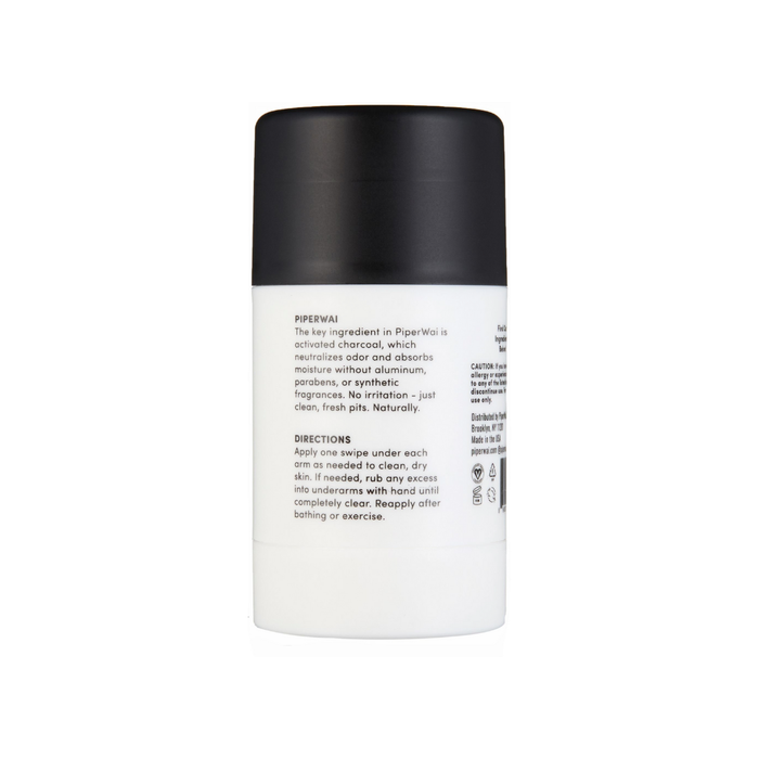 The PiperWai Natural Deodorant Stick is packaged in a stylish white container with a black cap and includes activated charcoal. The back label includes essential product information and usage directions.