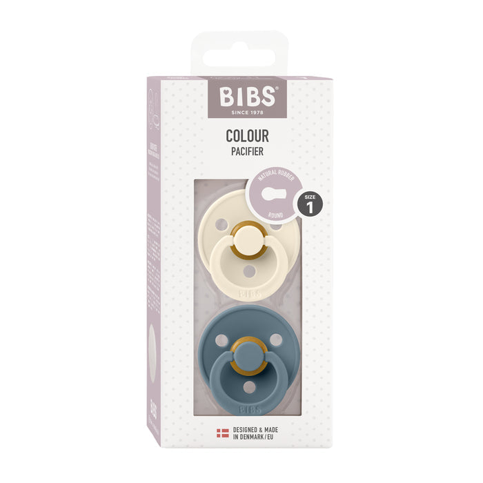 The BIBS Natural Latex Rubber Pacifier, Size 1 (0-6 Months), comes in a box with two BPA-free pacifiers—one cream, one teal—made from natural rubber. The label highlights the round shape, Danish design, and breastfeeding support qualities.