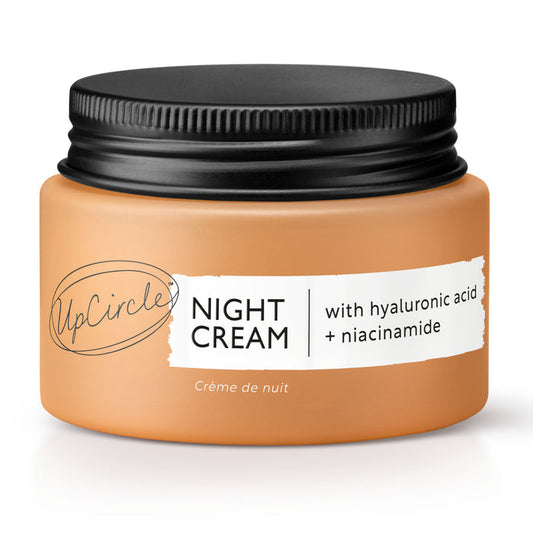 The UpCircle Night Cream, featuring a black lid and a muted peach label inscribed with Night Cream, elegantly highlights hyaluronic acid, niacinamide, and rejuvenating blueberry extract.