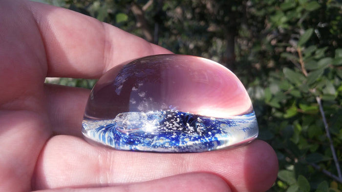 Purple Nightswirl glass paperweight showing a swirling space scene infused with cremation ash